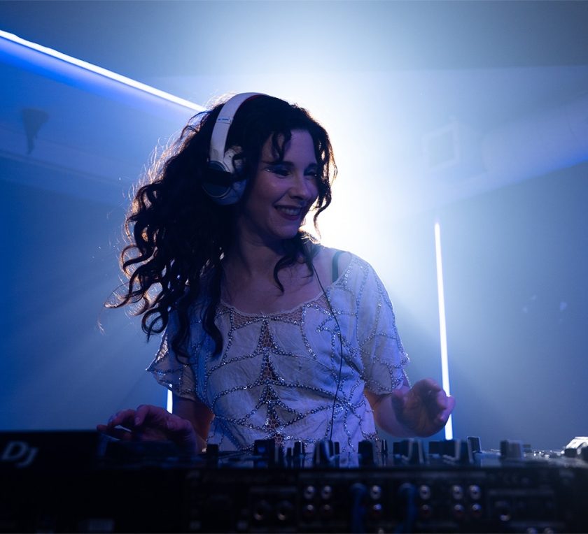 A picture of a woman dj-ing with blue light